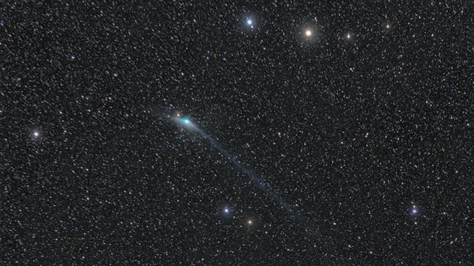 Kometa mezi „nebeskými vozy“. Astronomickou fotografií dne je český snímek